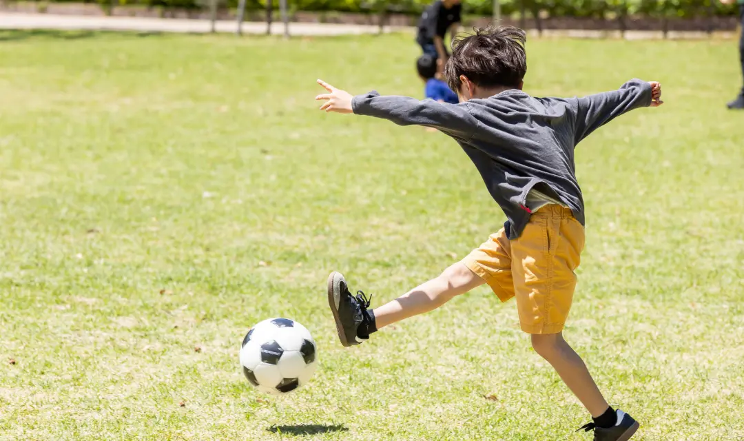 サッカーボールを蹴る子ども